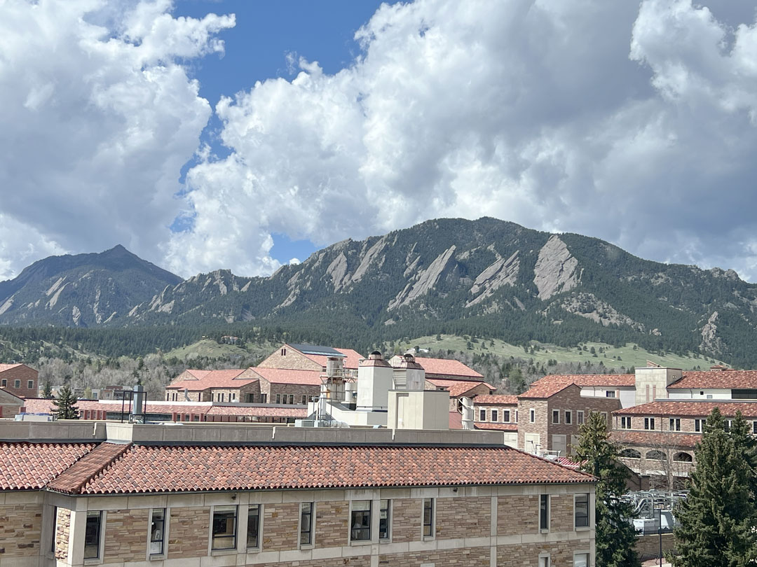 Photo of campus buildings with mountains in the background